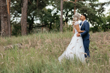 Kissing bride and groom standing in the park