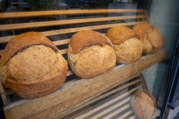 Showcase shelf with round breads in bakery. Closeup.