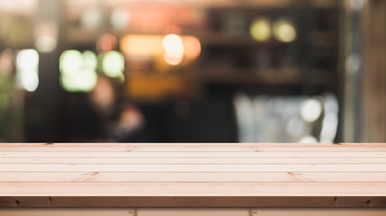 Empty wooden table top with lights bokeh on blur restaurant background