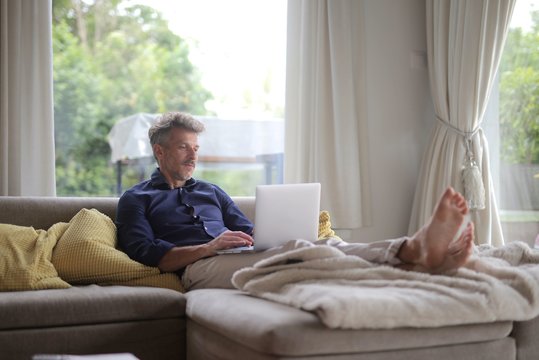 man with laptop on a sofa