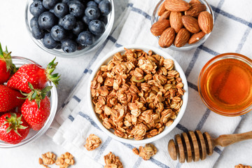 Homemade oatmeal granola bowl with berries on white background.