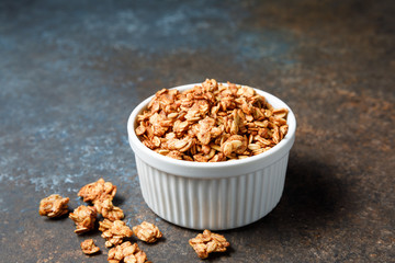 Homemade oatmeal granola bowl on dark background.