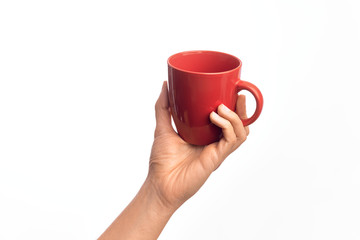 Hand of caucasian young man holding cup of coffee over isolated white background