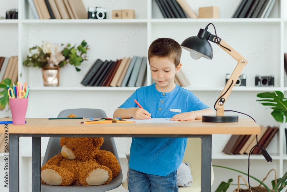 Wall mural education, childhood, people, homework and school concept - smiling student boy with book writing to