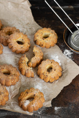 Lots of shortbread on baking paper on the oven surface. Homemade cake. Top view, close-up