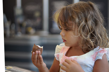 a 4 year old girl looks at the chocolate egg in a supermarket
