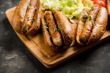 Tasty fresh hot dogs with grilled sausage on the rustic background. Selective focus. Shallow depth of field.