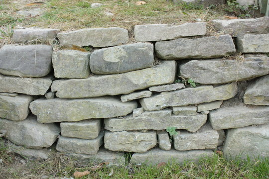the gray snote wall and green grass