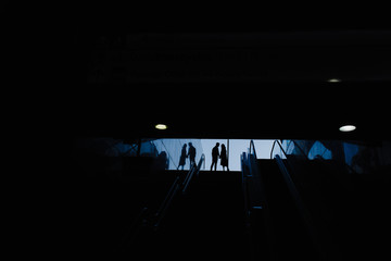 Silhouettes of a woman and a man in an underpass.
