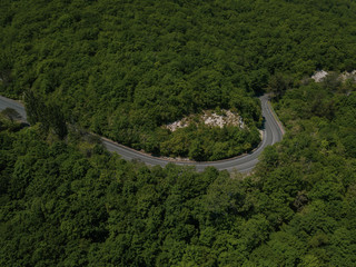 Mountain winding zig zag road. Top aerial view: cars driving on road from above.