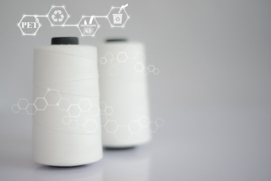 Polyester stable fiber & Raw White Polyester FDY Yarn spool with Blurred white background.Chemical Icon concept.