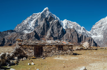 Picturesque view authentic tibetan habitation and stone fence in the Khumbu region in Nepal with majestic Taboche mountain 6501m on background. Remote traveling gems concept image.