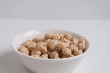 Balls for Breakfast, top view. A white plate filled to the top with Breakfast balls. Morning, light colors.