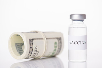 Expensive COVID-19 vaccine economy collapse impact currency concept. Close-up photo of vaccine vial and money stack isolated on white background