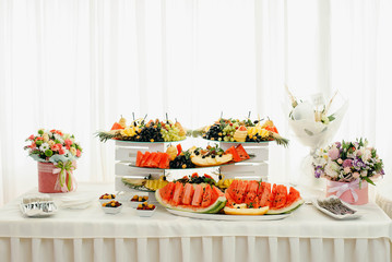 Buffet table with fruit. Wedding catering. Watermelon, grapes, melon, berries, pineapple on the buffet table.