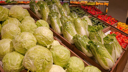 Cabbage, Beijing cabbage, tomatoes, peppers and other vegetables are in the drawer on the shop window.