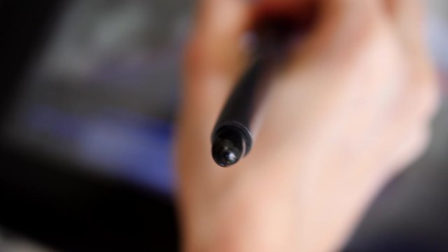 Computer graphic artist hand drawing with pencil on tablet