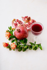 Pomegranate juice and fruits with flowering branches
