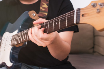 close-up of a man playing electric guitar