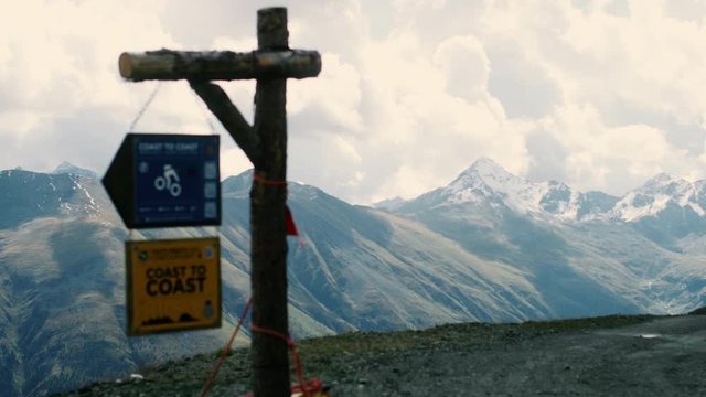 Landschaftaufnahme von Bergen in den Schweizer Alpen mit Schild f&uuml;r Wander- und Fahrradweg gefilmt mit RED Scarlet-W