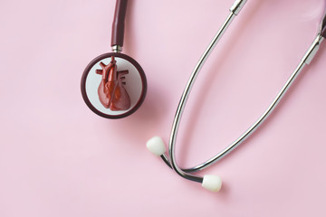 Fototapeta premium Human heart on stethoscope on pink background