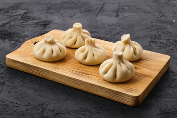 Uncooked khinkali on wooden board