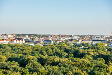 Panoramic city view of Berlin, viewfrom the top of the Berlin Victory Column in Tiergarten, Berlin, with modern skylines and green forest.