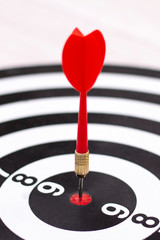 Dartboard with hit bullseye on white background, closeup. Bullseye is a business target. Target concept. vertical photo