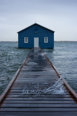 Blue boat house on the Swan River in Perth. Blue boat shed in Storm from cyclone mangga. Perth,...