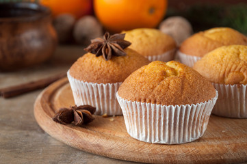 Delicious freshly baked muffins on a wooden table with star anise ready for graying with tea or coffee. Selective focus. Christmas spirit. Sweet dessert.