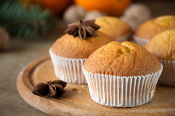 Delicious freshly baked muffins on a wooden table with star anise ready for graying with tea or coffee. Selective focus. Christmas spirit. Sweet dessert.