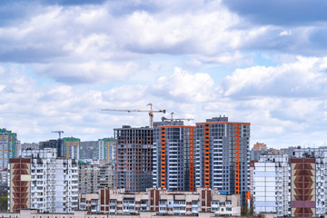 The concept of building technology, investment in real estate, mortgages, housing. The construction of new houses in the Obolonsky district of Kyiv against a cloudy sky. Kyiv (Kiev), Ukraine, Europe.