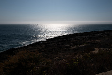 Panorama of the sea with a sailboat against daylight in Caiscas.