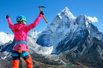 Woman climber at the top of mountain peak in Nepal, Everest region.