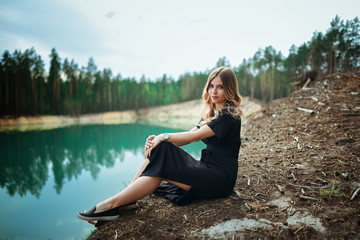 Fototapeta na wymiar A beautiful young girl at the blue lake