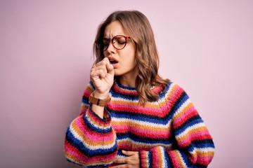 Young beautiful blonde girl wearing glasses and casual sweater over pink isolated background feeling unwell and coughing as symptom for cold or bronchitis. Health care concept.