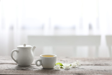 White tea cup and tea pot on wooden table minimal interior  