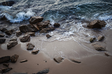 rocas en la playa siendo acariciadas por el agua del mar mediterráneo