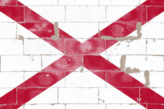 Alabama USA state flag white color with red stripes cross on independence day on brick wall background. Political and religious disputes, customs and delivery.