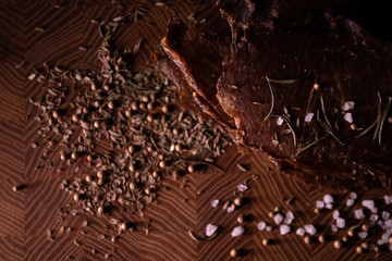Close-up of a piece of meat on a wooden Board with spices. Restaurant menu, a series of photos of different dishes