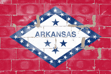 Arkansas state flag blue and white on red painted on old brick wall on Independence Day. Political and religious disputes, customs and delivery.