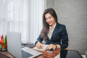 Attractive businesswoman with laptop working in office her.