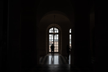 silueta de un hombre mirando por la ventana dentro de un cuarto oscuro