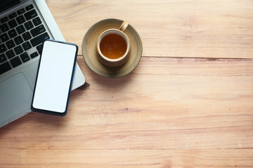  smart phone with empty screen and laptop on wooden background 