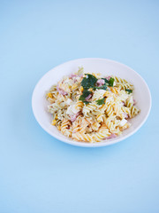 colourful pasta salad dish on a blue table