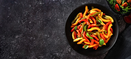 Top view of colorful Italian pasta in a plate on black background