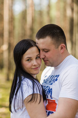 Fototapeta premium woman hugs her husband. happy married couple. to love your husband. family idyll in the woods. walks in the fresh air
