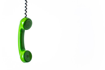 Old retro green phone headset with twisted cord hanging
