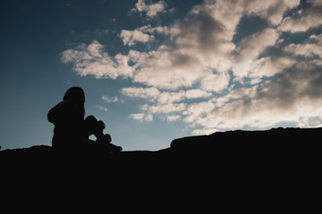 silueta de una mujer mirando las nubes del atardecer