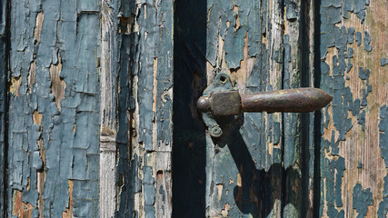 Alte Holztür mit schönen Details und abblätternder Farbe, alte Türklinke